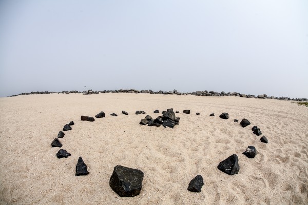A ring of beach rocks seen through the Sigma 15mm EX DG HSM Diagonal Fisheye with the horizon line near the center of the frame.