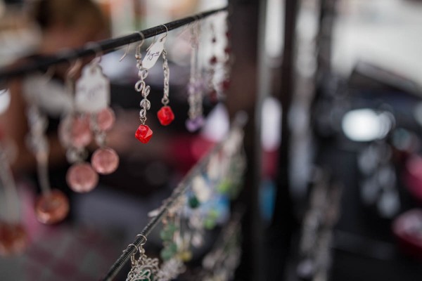 An earring hangs on a display rod at an artisan's market. 1/800 F2 ISO 100 at 35mm on a Canon EOS 6D. 