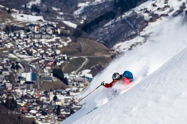My previous shot had been shot wide and my next shot would be mid telephoto.  This time my skier is deep in powder while the town of Disentis enjoys spring thousands of feet below. ISO 200 at 189mm f/8  1/1250sec.