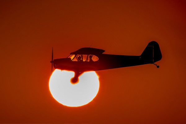© 2016 Jim Koepnick | Silhouetted by the setting sun, Luke prepares to land his Piper Cub. Sigma 150-600 Sport; Canon 1DX; 1/4000 sec at f9; ISO 250.