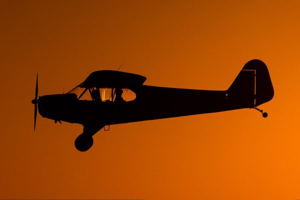 © 2016 Jim Koepnick | Even without the sun in the photo, the orange sky at sunset gives a nice silhouette to this Piper Cub. Sigma 150-600 Sport; Canon 1DX; 1/4000 sec at f9; ISO 250.